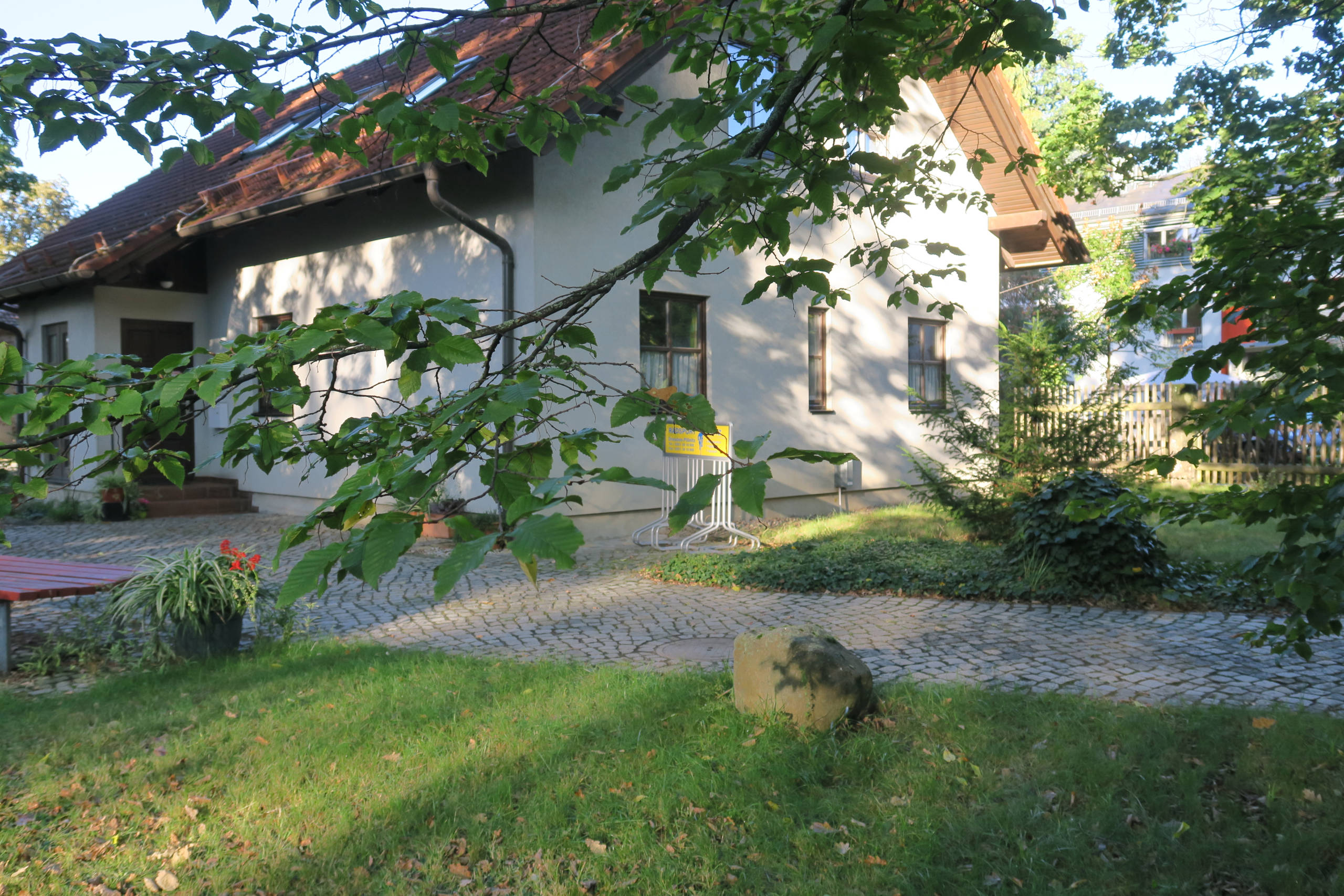 Weißes Gebäude der Praxis von außen mit Dachfenstern